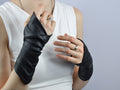 Woman in white top wearing black faux leather fingerless arm warmers, unisex steampunk gloves – ZOLNAR