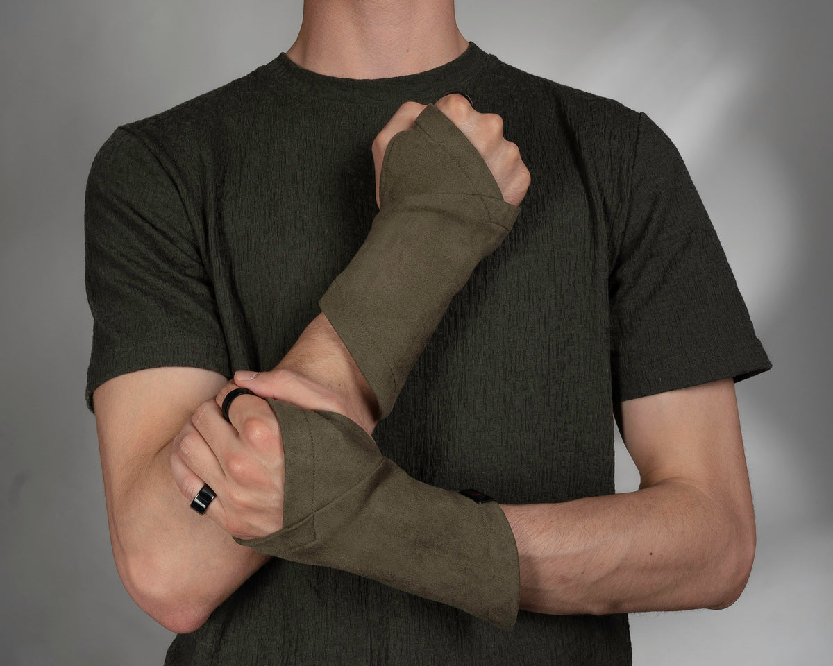 Khaki faux suede arm warmers on man in dark T-shirt, one hand raised to chest – ZOLNAR