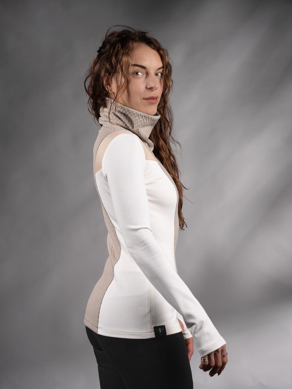 Side profile of white and beige futuristic sweater with black trousers – ZOLNAR