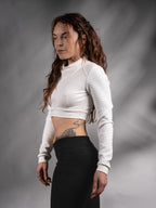 Woman in white cyberpunk crop top with sculptural draped collar, three-quarter view, futuristic – ZOLNAR