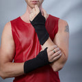 Man in red faux leather top wearing black suede fingerless gloves, one hand raised – ZOLNAR